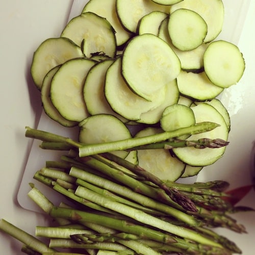 Snijd de courgette in dunne plakjes en halveer de asperges.